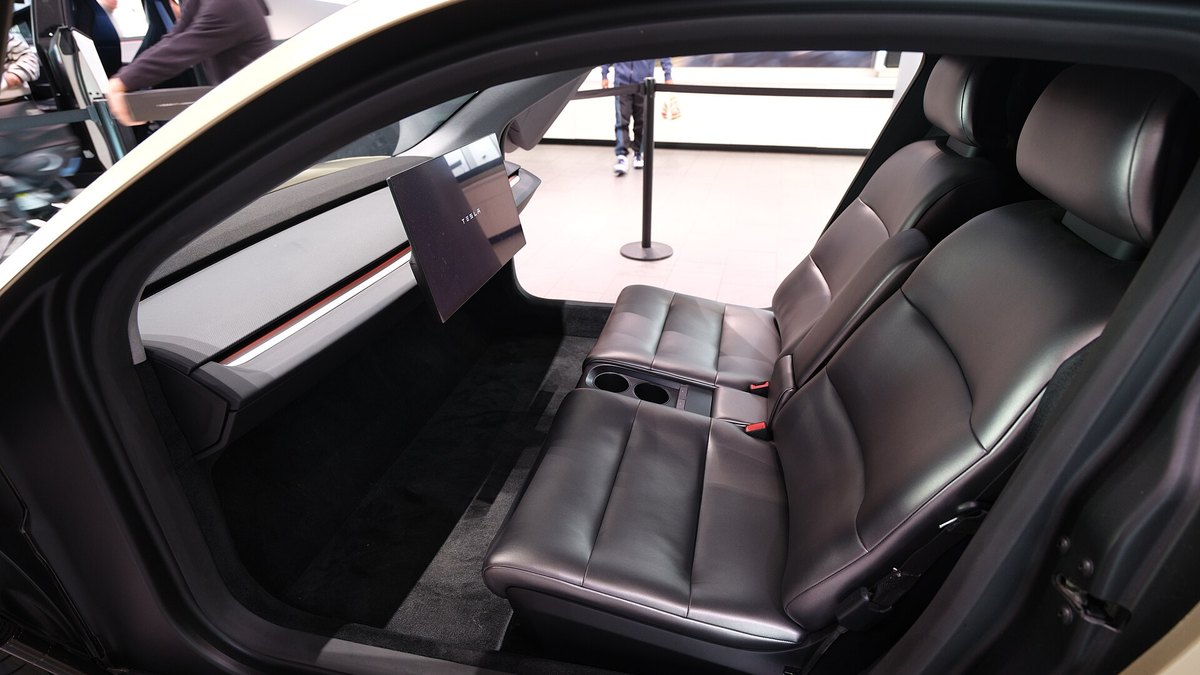 The leather rear and front seats of a Tesla Cybercab display car seen through the open door
