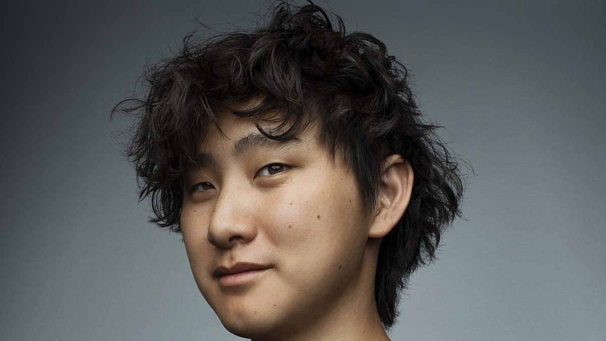 Close portrait of Alexandr Wang, Meta's Chief AI Officer, against a gray studio background