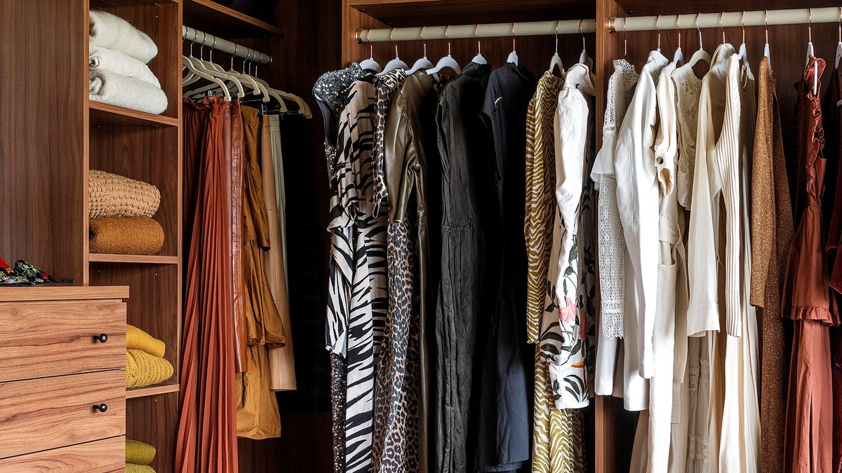 A custom walk-in closet with built-in shelving, drawers and hanging rods