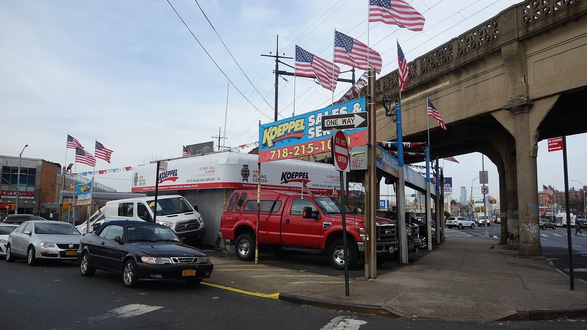 A dealership sales and service lot beside an elevated railway line