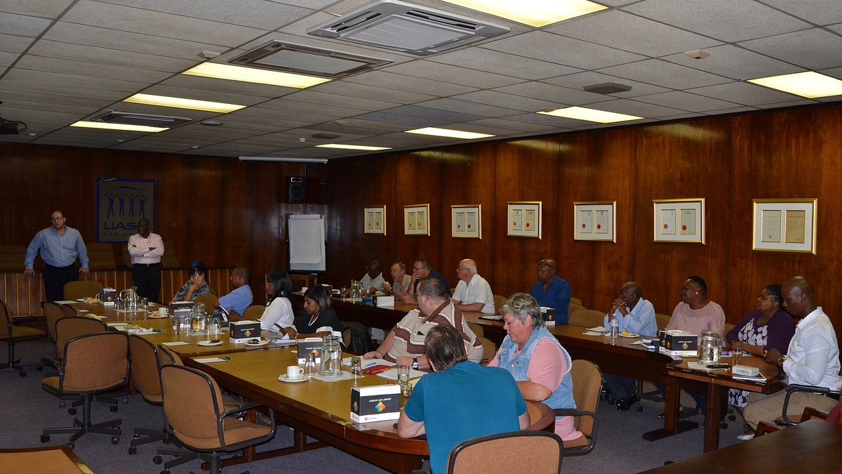 A meeting around a long boardroom table